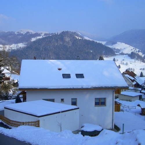 Au&szlig;enansicht des Hauses Jaufman im Winter mit verschneiter Landschaft im Hintergrund - 