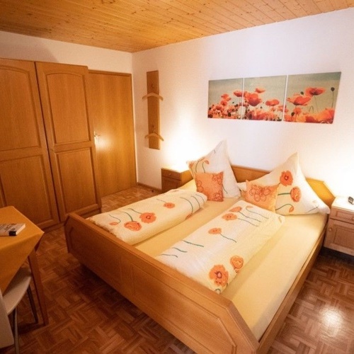 Schlafzimmer mit Doppelbett, zwei Nachtischen und Holzschrank  - 